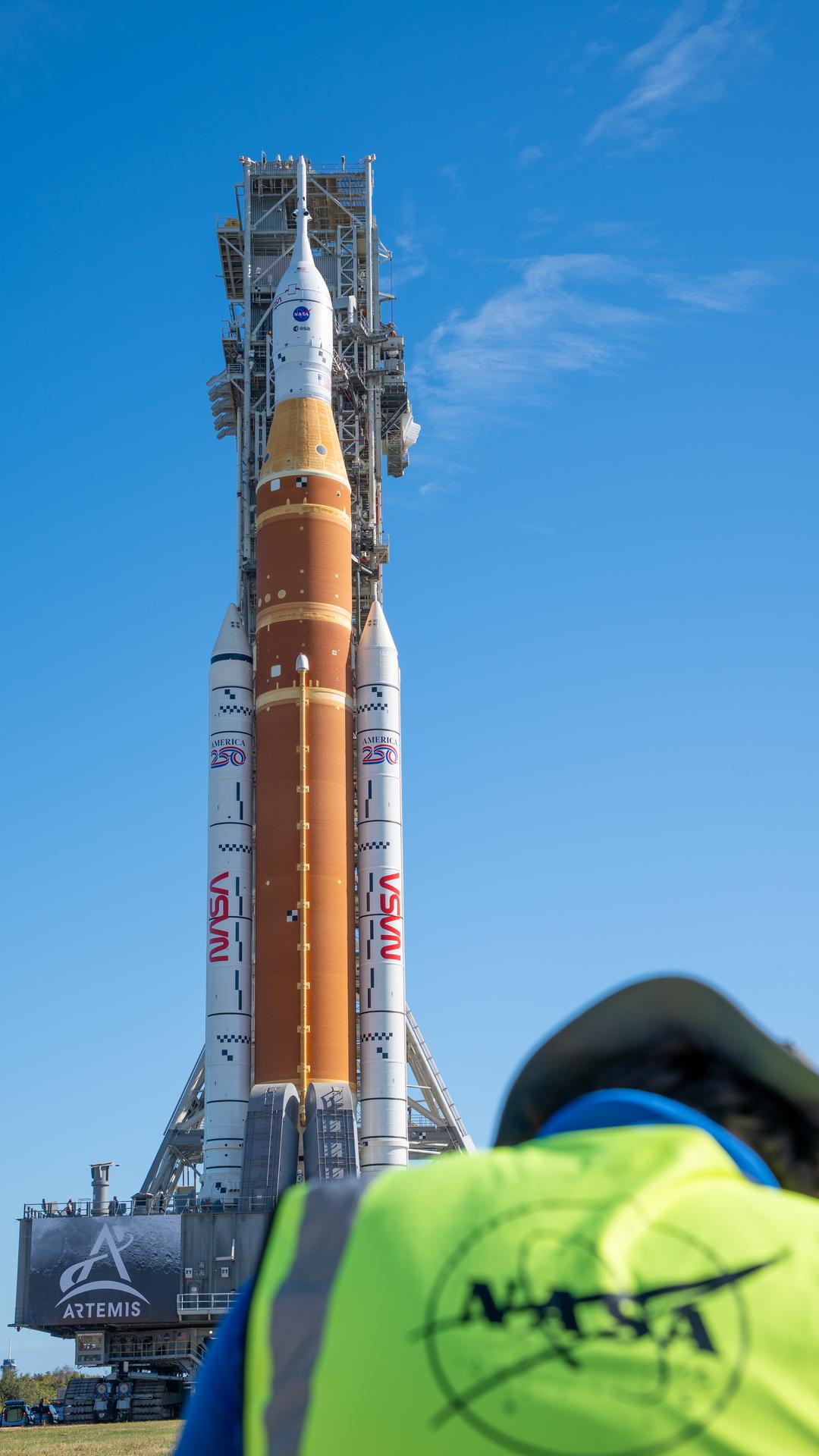 This image shows NASA’s SLS (Space Launch System) and Orion spacecraft rolling out of the Vehicle Assembly Building at NASA’s Kennedy Space Center. NASA's massive Crawler-Transporter, upgraded for the Artemis program, carries the powerful SLS rocket and Orion spacecraft on the Mobile Launcher from the Vehicle Assembly Building to Launch Pad 39B at Kennedy Space Center in preparation for the Artemis II mission.